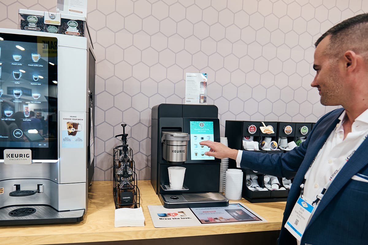 Man selects a hot beverage from a machine.